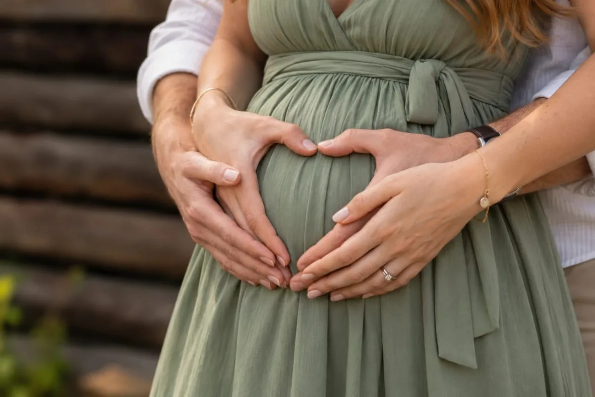 Будущие родители складывают руки сердцем на животе